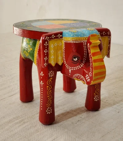 Handcrafted mango wood elephant ottoman stool with hand-painted Rajasthani folk art used as a bohemian side table in living room