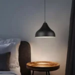 Close-up of the 3-head chandelier showing the textured iron surface and cone-shaped shades.
