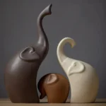 Overhead shot of the elephant figurines on a glass shelf, showing their matte finish and shadows.