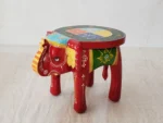 Handcrafted mango wood elephant ottoman stool with hand-painted Rajasthani folk art used as a bohemian side table in living room