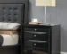 Black nightstand with drawers and pull-out tray in a modern bedroom setting