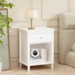 White wooden nightstand with one drawer and one shelf, 26.77 inches tall, placed beside a bed