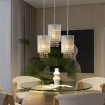 Chrome spiral pendant light with crystal stripes hanging over a modern kitchen island, bright ambient lighting.