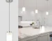 ETL brushed nickel mini pendant light with dual glass shades over a dining table in a modern kitchen.