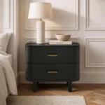 Modern minimalist black nightstand with two drawers and wood handles beside a bed in a contemporary bedroom