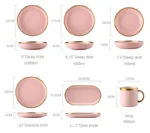 Elegant dinnerware set with gilt rim pink porcelain plates, bowls, mugs, and cutlery on a table