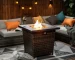 Square propane fire pit table with wicker base on patio