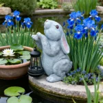 Solar powered rabbit garden statue with glowing LED eyes, sitting on green grass in a sunny backyard.