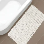 Beige non slip bath mat with pebble texture in bathroom