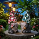 Resin gnome statue with solar light, featuring smiling face and floral cutouts.