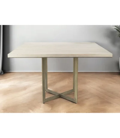 Modern square dining table with gold metal X-shaped base and light beige brown wood top