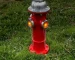 Solar garden statue fire hydrant with glowing LED and paw print detail in a flower bed