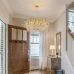 Modern crystal chandelier tree branch design illuminating a dining room