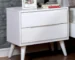 White mid century bedside table with two drawers in a modern bedroom setting