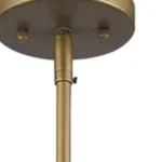 The HMS hanging light against a dark wall, its brushed gold finish contrasting with the shadow, emitting a cozy 3000K