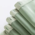 Modern grid sage green shower curtain with waterproof PEVA material in a bright bathroom