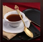 24-piece stainless steel cutlery set with gold handles displayed on a wooden table