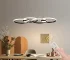 4-Ring LED Pendant Light in black metal, dimmable modern chandelier hanging above a dining table in a contemporary