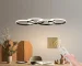 4-Ring LED Pendant Light in black metal, dimmable modern chandelier hanging above a dining table in a contemporary