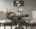 Modern round dining table in solid wood with grey finish in a cozy dining room setting