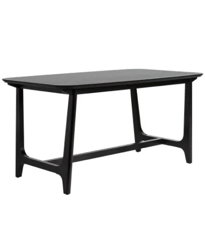 Mid-century modern dining table with black ash veneer top and trestle base in a dining room setting