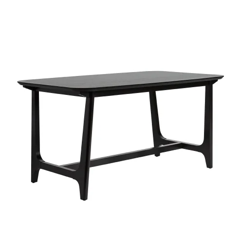H1e4591b9028642b98a198356fca392b7b.webp Mid-century modern dining table with black ash veneer top and trestle base in a dining room setting