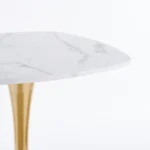 Modern square dining table with marble top and gold metal base in a small apartment dining room