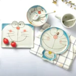 Japanese ceramic dinnerware set with hand-drawn cat design on blue rectangular plate and bowl