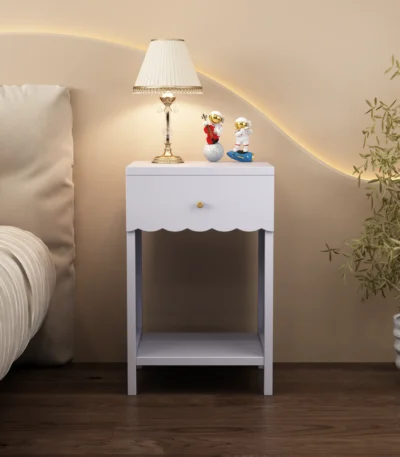 Modern nightstand with scalloped edge drawer and open shelf in lilac color, placed beside a bed