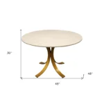 Elegant round marble dining table with ivory marble top and brass pedestal base in a modern dining room