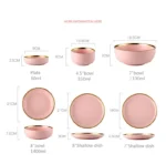 Elegant dinnerware set with gilt rim pink porcelain plates, bowls, mugs, and cutlery on a table