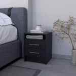 Modern black melamine nightstand with two drawers and shelf beside a bed in a bedroom