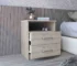 Olienza nightstand with drawers in light gray next to a bed