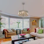 Goldoma pendant light with chrome frame and crystal accents, hanging at its lowest adjustable height.