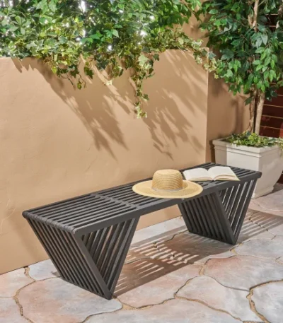 Dark gray solid wood outdoor garden bench with cast iron legs in a garden setting