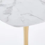 Modern square dining table with marble top and gold metal base in a small apartment dining room