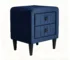 Navy blue bedside table with velvet finish and two drawers in a modern bedroom setting