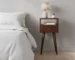 Chestnut brown solid wood nightstand with drawer and open shelf in bedroom