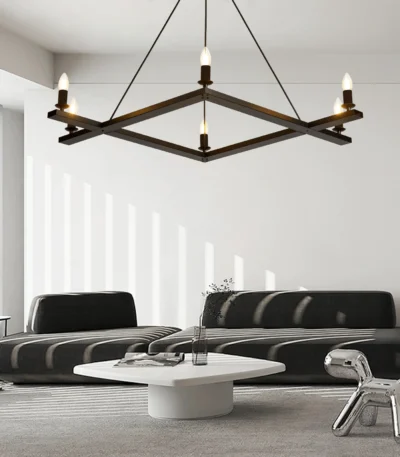 Farmhouse chandelier in black metal with candle-style lights, centered over a wooden dining table in a cozy room.