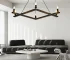 Farmhouse chandelier in black metal with candle-style lights, centered over a wooden dining table in a cozy room.