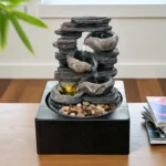 Side view of the Goldoma tabletop fountain highlighting the layered stone design and the gentle waterfall effect, USB