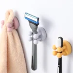 Two-piece set: white silicone toothbrush holder and shaving holder on a bathroom counter.