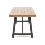 Outdoor acacia dining table with teak finish and metal base on a patio