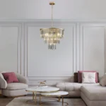 Close-up of the 7-light gold frame chandelier, showing clear crystal droplets and intricate metalwork against a white