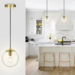 Brass ceiling pendant light with glass ball shade hanging over a wooden kitchen island, warm glow.