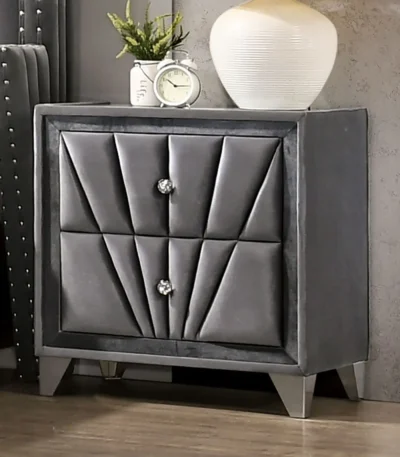 Gray fabric upholstered nightstand with chrome legs and drawers in a modern bedroom setting