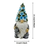 Gnome decor statue placed among flower beds, emitting soft light through cutout flowers.