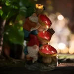 Goldoma solar gnome statue glowing at night in a garden, ceramic resin material with warm LED light.