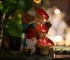 Solar gnome statue glowing in garden at dusk