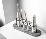 Toothbrush holder with a wide base and a toothpaste squeezer in a bright bathroom.